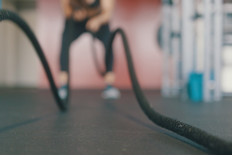 A person catching their breath after an intense interval workout, hands on knees