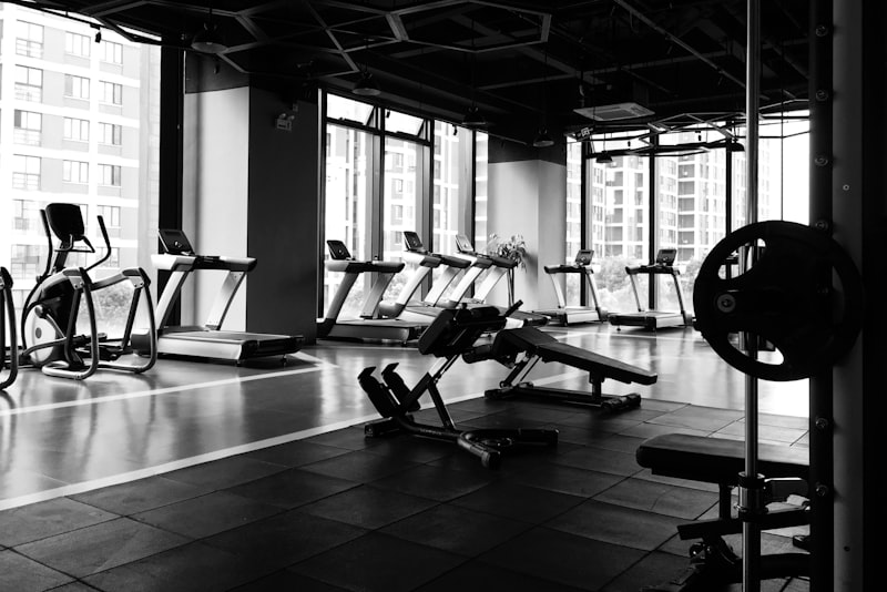 A person mid-set in a bright gym, gripping a barbell with focused calm